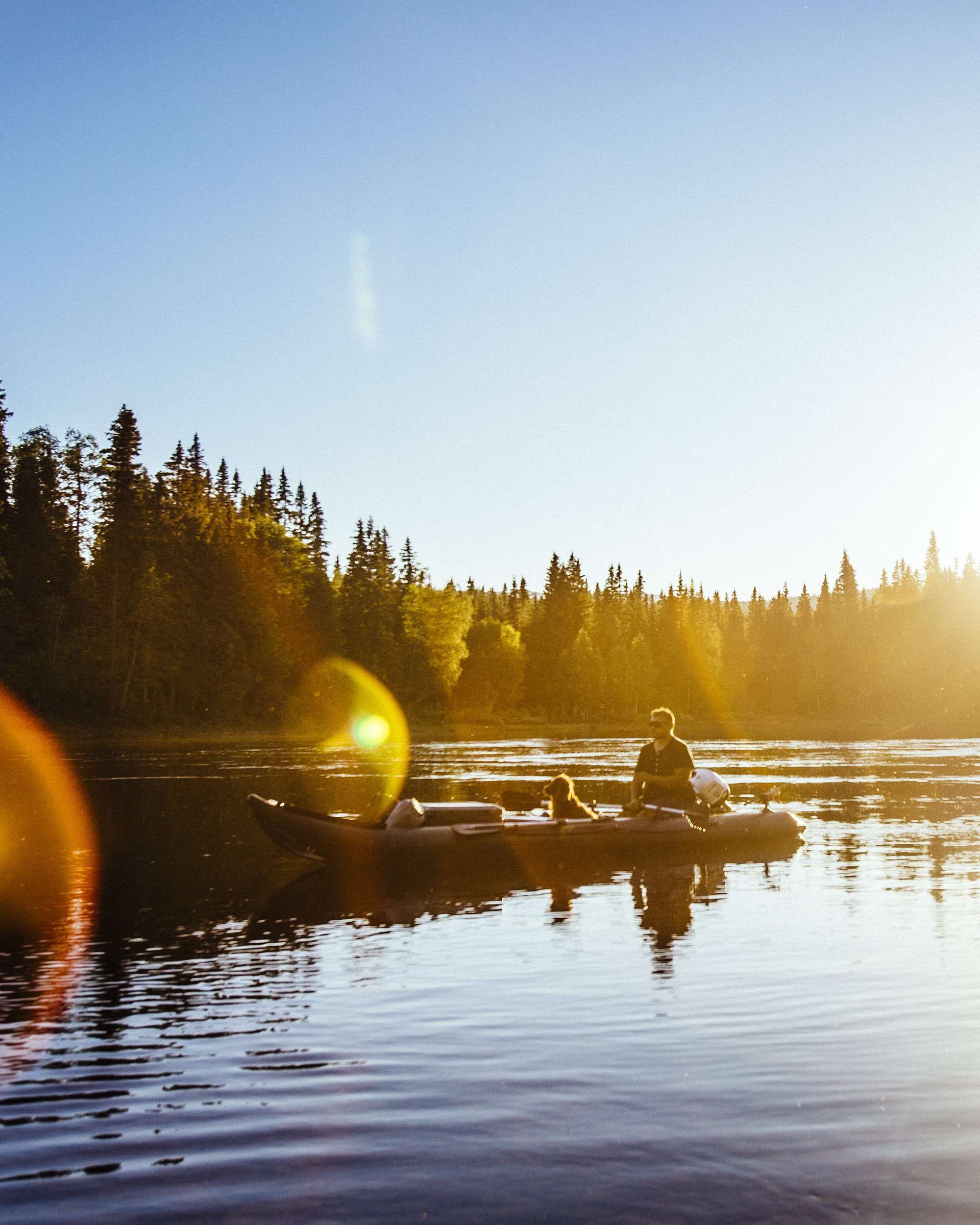 kaboat på en älv i solnedgången i fjällen